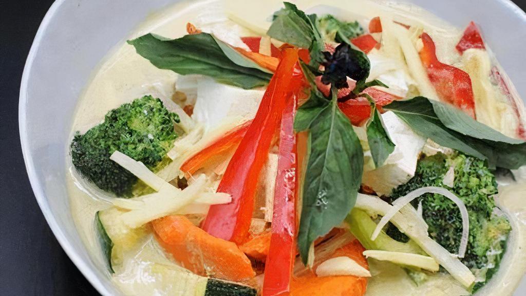 Green Curry · Soft/fried tofu with seasonal vegetables, bamboo shoots, bell peppers. Cooked with green curry, topped with fresh basil leaves.