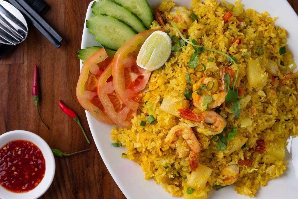 Pineapple Fried Rice* · Jasmine rice stir fried with yellow curry powder, pineapple, egg, cashew nuts, peas, carrots and onions.