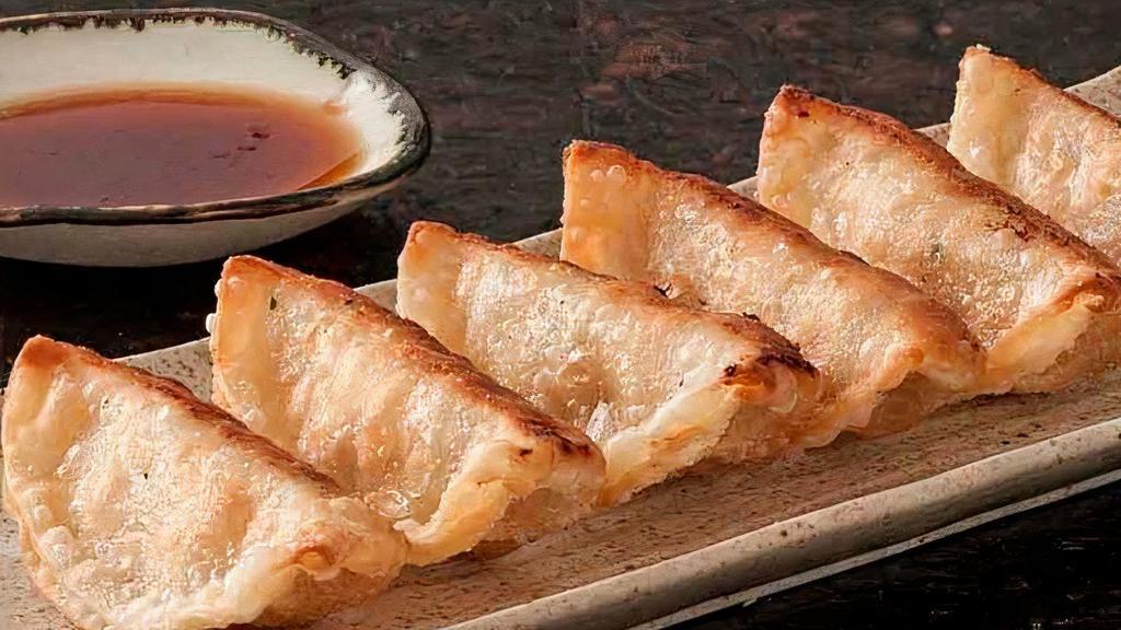 Gyoza · Eight Japanese dumplings filled with chicken and vegetables served either fried or steamed with a side of gyoza sauce.