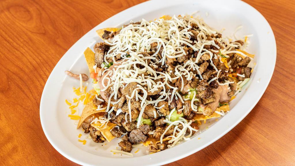 Super Nachos · Your choice of meat with rice beans guacamole cheese on top of nacho chips