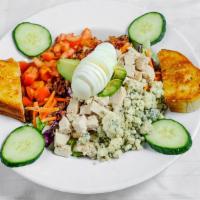 Cobb Salad · Mixed greens layered with blue cheese tomatoes, grilled chicken, bacon, eggs avocado and cuc...
