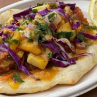 Naan Tacos · Hand-rolled naan tacos with house-made mango salsa and red cabbage topped with house hot tik...