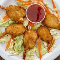 Butterfly Coconut Shrimp · Coconut shaves battered shrimp, served with sweet chili sauce over a bed of cabbage.