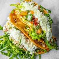 Crispy Beef Brisket · Lettuce, pico, sour, guacamole, guajillo sauce, and cojita.