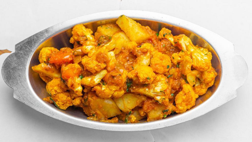Aloo Gobhi (V) · Vegan. Cauliflower cooked with potato, ginger, garlic, tomato and spices.
