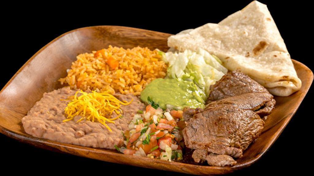 Carne Asada Plate · Grilled steak topped with pico de gallo, guacamole, and lettuce. Comes with one flour tortilla.