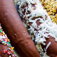 Banana Dipper · Banana dipped in chocolate and topping of your choice: plain, coconut, peanuts, or sprinkles.