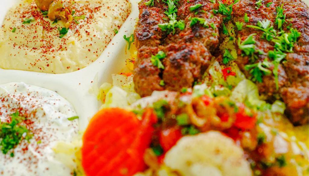 Kabab Plate · Rice, kabab, hummus, tzatziki, lettuce, tomatoes, pickles, and pita bread.