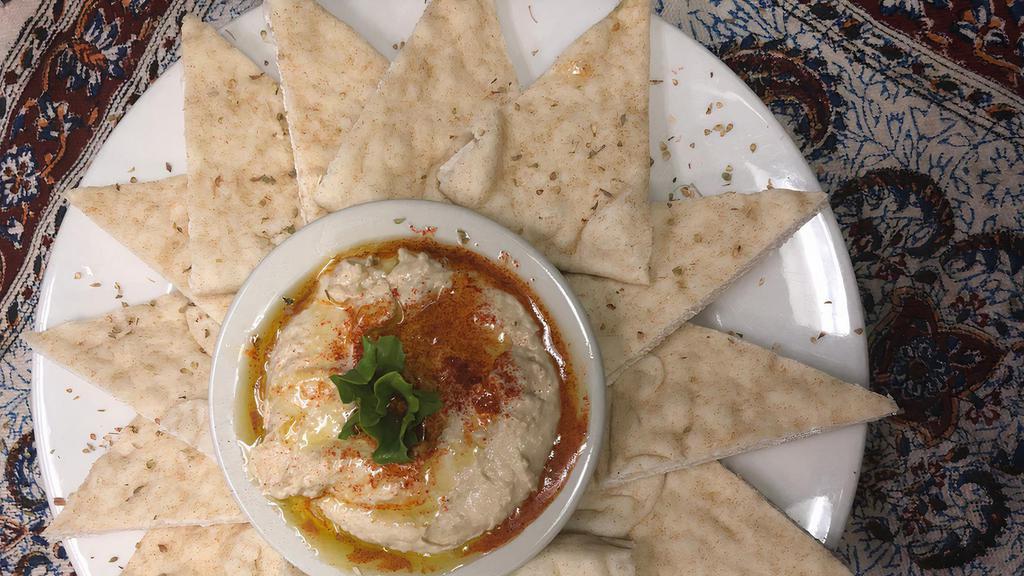 Hummus · Chickpeas blended with tahini, olive oil, garlic, and herbs, served with pita bread.