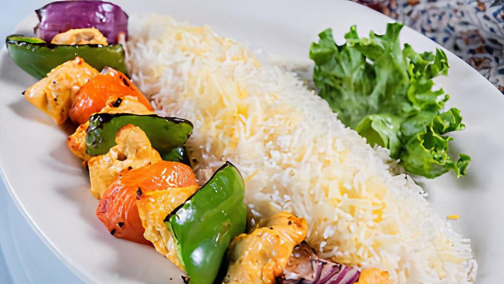 Shish Kebab · Marinated kebab with bell pepper, tomato, and onion broiled over an open fire, served with rice.