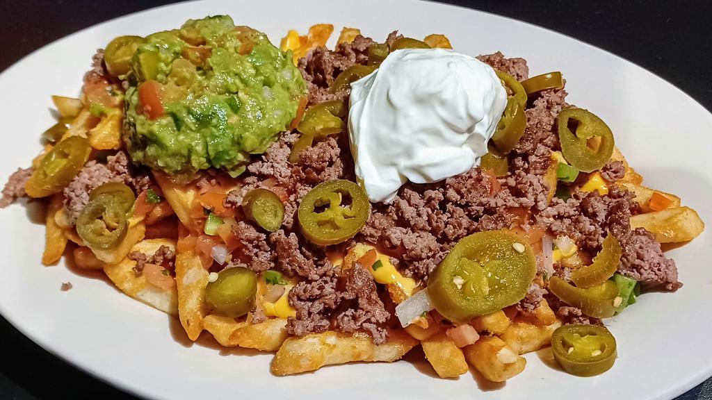 Loaded Fries With Beef Or Chicken · Large plate of golden fries layered with nacho cheese, topped with ground beef or chicken with homemade pico De gallo, guacamole, jalapenos and a dollop of sour cream