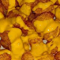 Nacho Cheese Tots · Basket of deep fried tater tots drizzled with nacho cheese