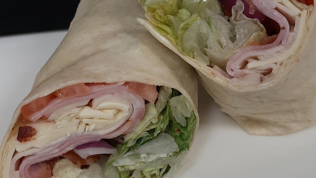 Deli Club Wrap · Romaine Lettuce, ham, turkey, bacon, American cheese, tomato, red onion and mayo rolled into a warm flour tortilla.
