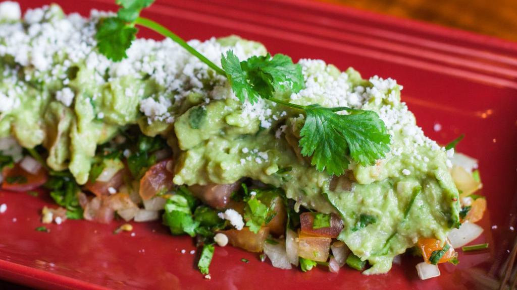 Guacamole Dip · Made with fresh avocado, cilantro, lime juice, tomatoes, and onions. Topped with spicy pico de gallo and queso fresco.