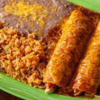 Enchiladas Tradicionales · Two filled corn tortillas covered in sauce and melted cheese served with rice and beans. Fil...