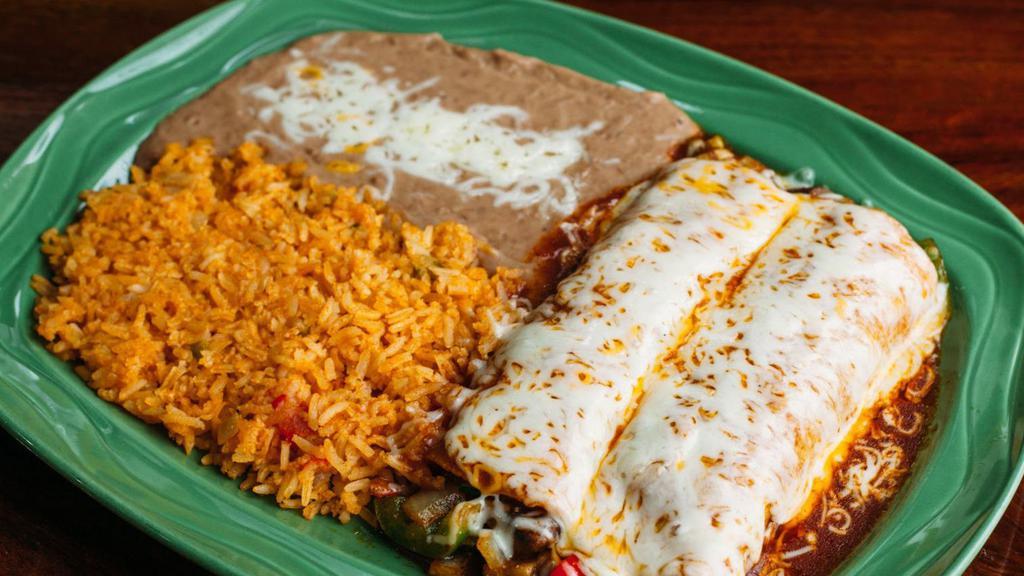 Veggie Enchiladas · Two filled corn tortillas covered in sauce and melted cheese, served with rice and beans. Filled with grilled bell peppers, onions, mushrooms, zucchini, 
tomatoes and topped with red sauce.