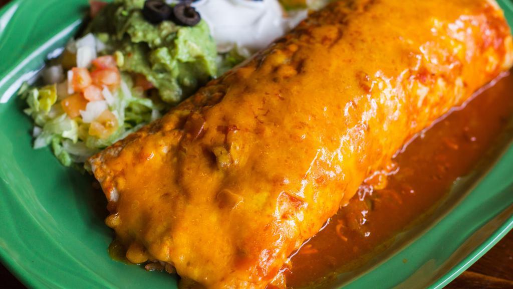 Deluxe Burrito · Flour tortilla filled with choice of meat, rice, and beans. Topped with red sauce, melted cheese, onions, lettuce, tomatoes, guacamole, sour cream, and olives. Choices: veggie, ground beef, shredded beef, or shredded chicken.