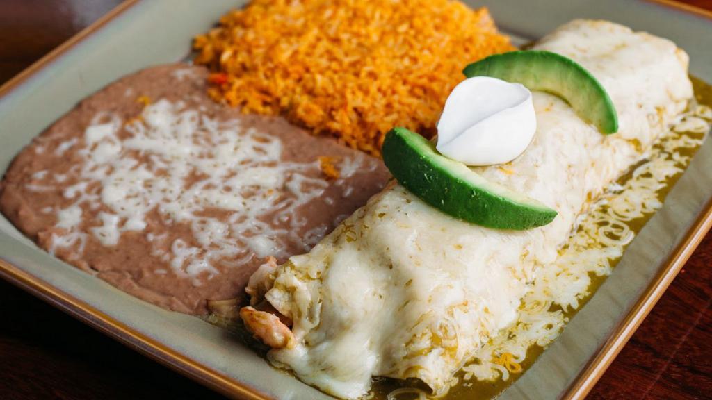 Burrito Veracruz · Sautéed choice of prawns, grilled chicken or steak with onions, green peppers, bell peppers, and mushrooms in a garlic cream sauce. Topped with green tomatillo cream sauce, Jack cheese, sour cream, and avocado slices. Served with rice and beans.