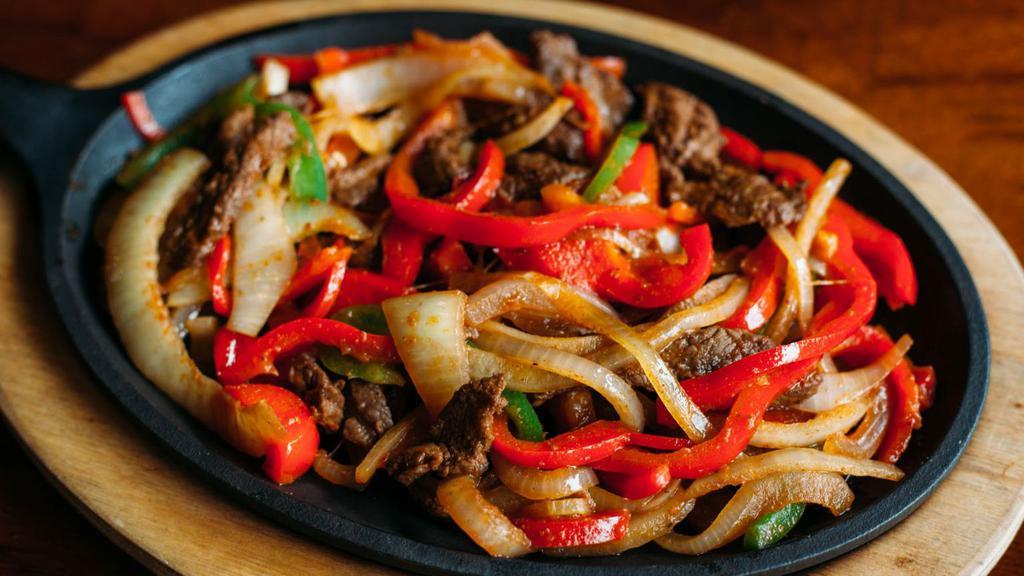 Fajitas · Choice of marinated meat sauteed with bell peppers and onions on a sizzling skillet. Served with rice, beans, lettuce, cheese, tomatoes, onions, olives, guacamole, sour cream, and flour or corn tortillas. Choice: Steak, Chicken, or Veggie.