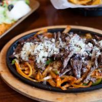 Texas Style Fajitas · Choice of meat sautéed with bell peppers and onions on a sizzling skillet. Served with rice,...