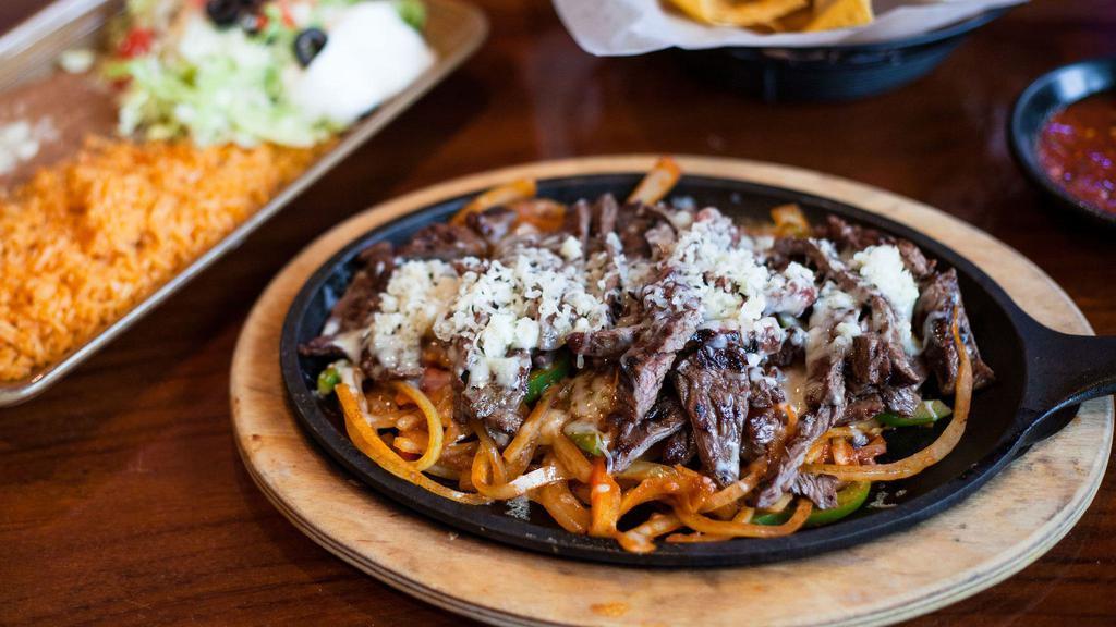 Texas Style Fajitas · Choice of meat sautéed with bell peppers and onions on a sizzling skillet. Served with rice, beans, lettuce, cheese, tomatoes, onions, olives, guacamole, sour cream, and flour or corn tortillas.