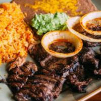 Carne Asada · Thinly sliced skirt steak cooked over charcoal. Served with grilled onions and guacamole.