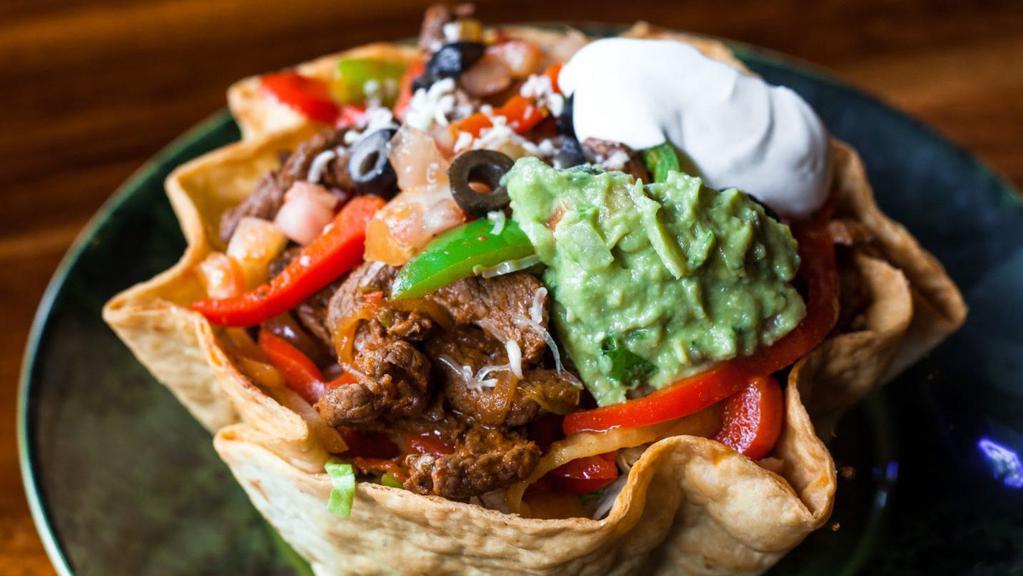 Deluxe Taco Salad · Lettuce, cheese, sour cream, guacamole, tomatoes, and onions. Choice: Steak, or Prawns Fajitas.