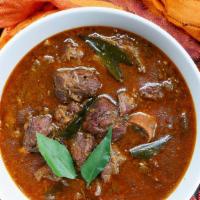 Traditional Goat Curry · Goat cooked in onion, tomatoes, garlic-ginger and spices.