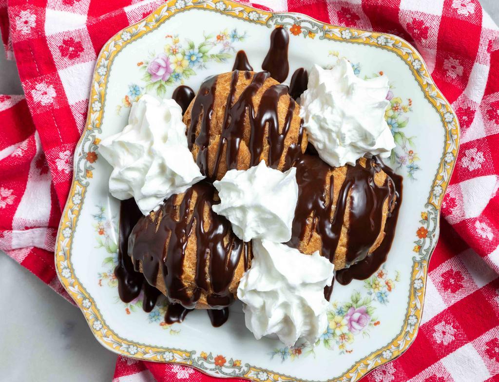Profittaroli · Cream puffs filled with whipped cream &
topped with a rich chocolate sauce.