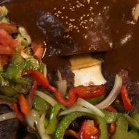 Steak Tampiqueña · Grilled skirt steak and one-mole chicken enchilada served with rice and beans green salad an...
