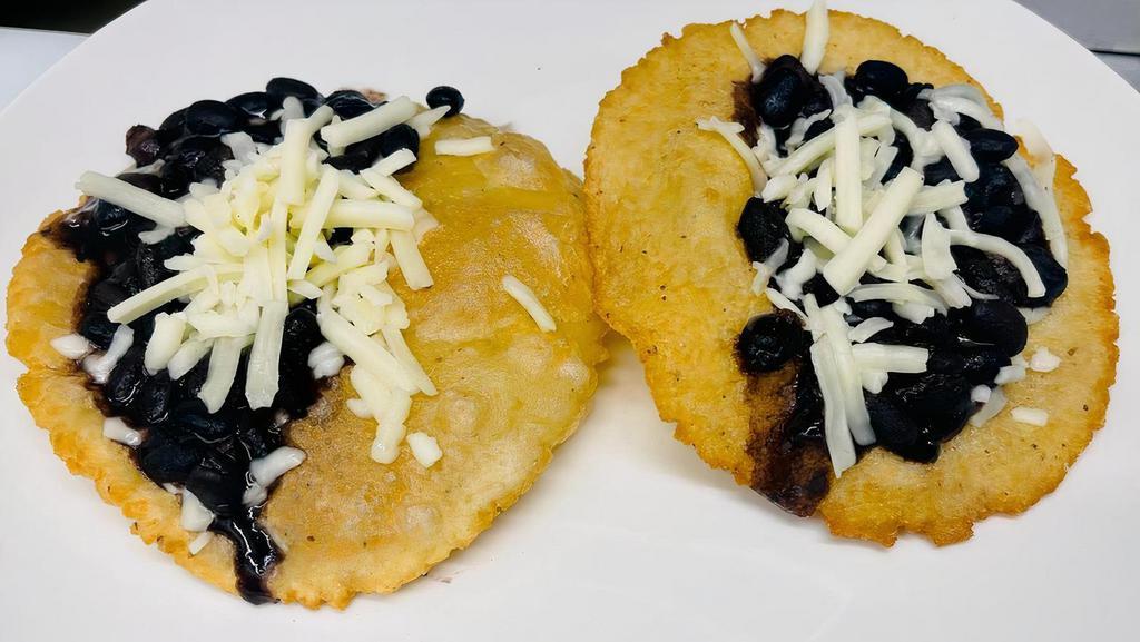 Bean And Cheese Fluffy Tacos · Two handmade deep fried tortillas, black beans and cheese.