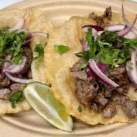 Carne Asada Fluffy Tacos · Two handmade deep fried tortillas, carne asada, pickled red onions, cilantro and lime.