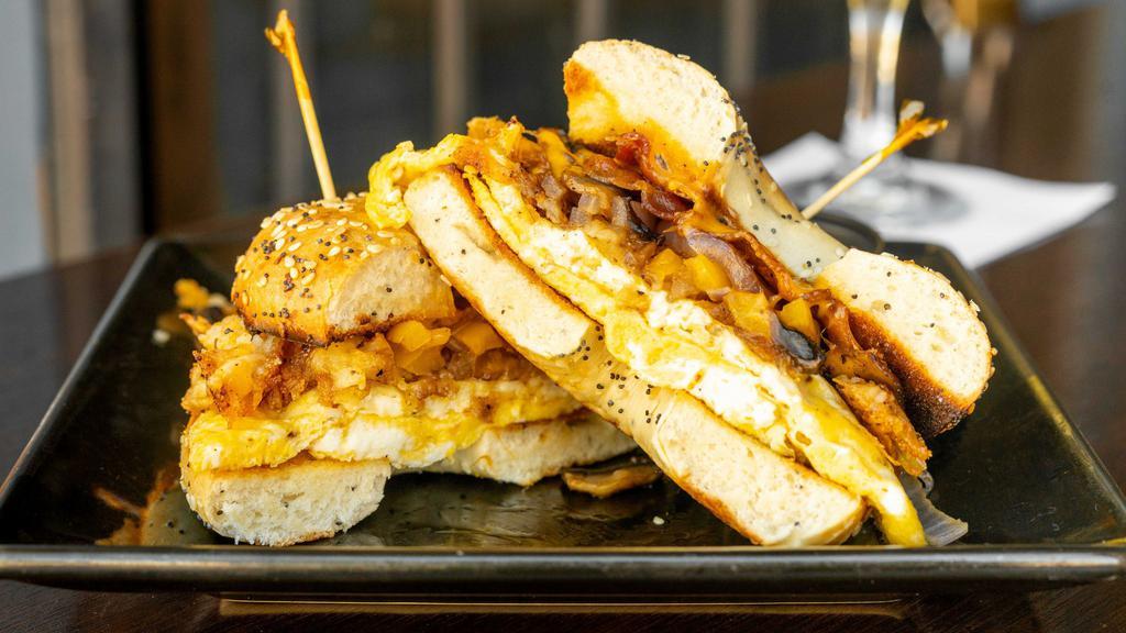 Breakfast Sandwich · Two eggs, choice of meat, onions, bell peppers, mushrooms, hash-browns all piled high topped with cheddar cheese on a freshly toasted bagel.