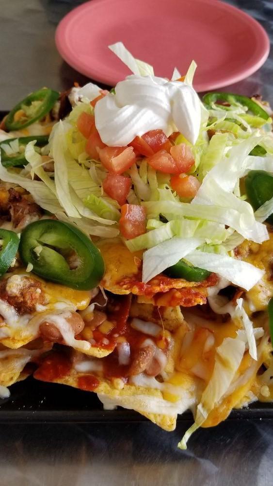 Red Chile Carne Nachos · Three fully loaded pounds of nachos, local beans, red Chile, carne adovada, jalapenos, lettuce, tomato, and sour cream.