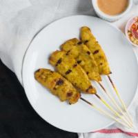 Satay · Grilled marinated chicken on bamboo sticks in coconut milk and curry powder served with pean...