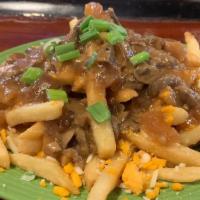Vegan Canadian Poutine Fries · Crispy french fries smothered with shredded mozzarella cheese & rich brown gravy.