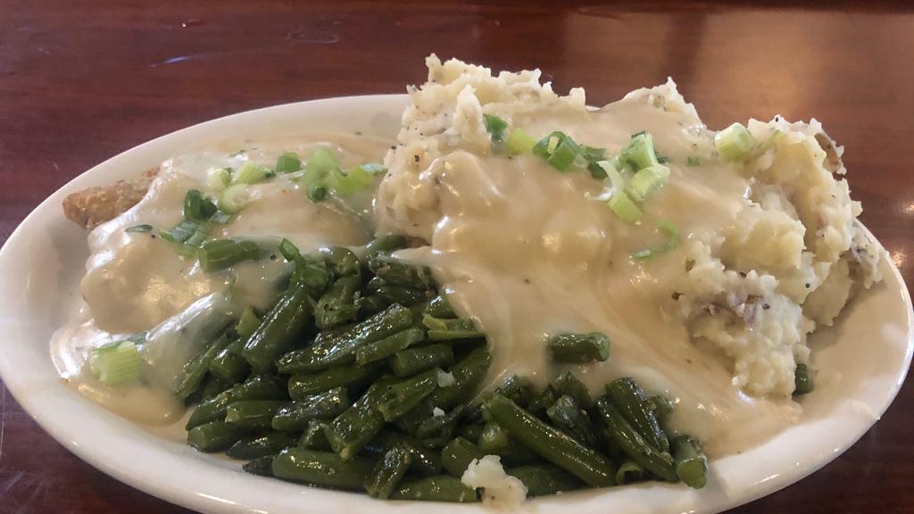 Redneck Dinner · A crispy chicken fried steak served with creamy mashed potatoes, country gravy and green beans with a dinner roll.