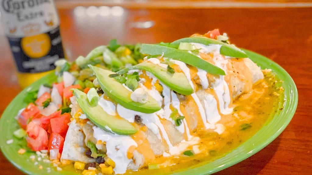 Veg Chili Verde Burrito · A huge flour tortilla filled with seared, brined jackfruit, potatoes, and roasted green chili verde then smothered with more chile verde and melted cheddar and mozzarella cheese. Served with black bean and corn salad, sour cream and guacamole.