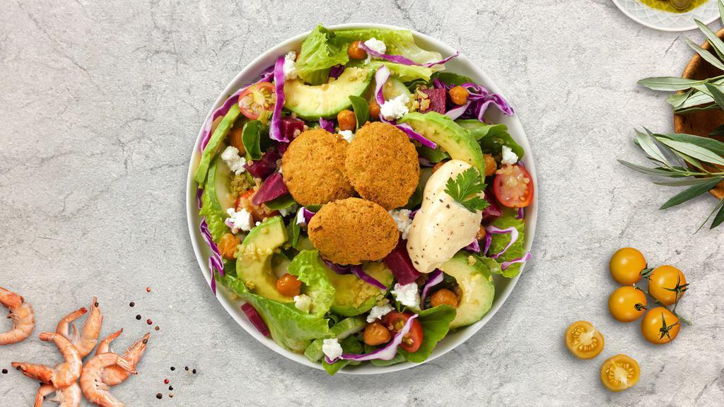 Lawfully Falafel · Arugula, romaine lettuce, red cabbage, tomatoes, cucumber, quinoa, fried chickpeas, avocado, feta, pickled beets, hummus, and falafel tossed with lemon tahini dressing.