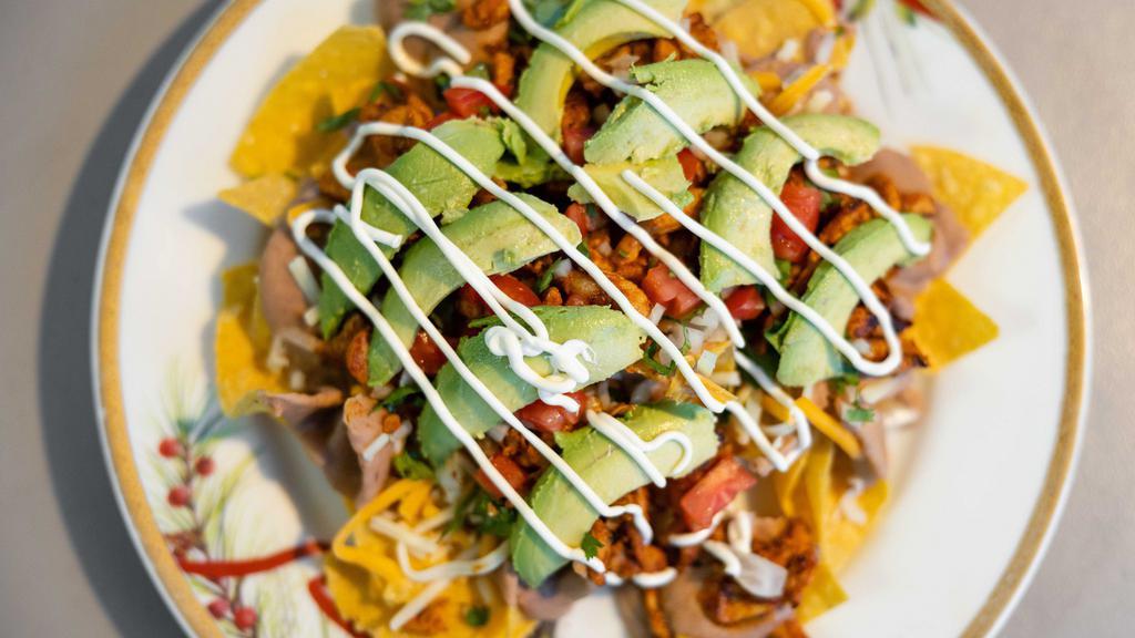 Nachos · Housemade chips with refried beans, cheese, tomato, avocado, pico de gallo, sour cream and choice of protein.