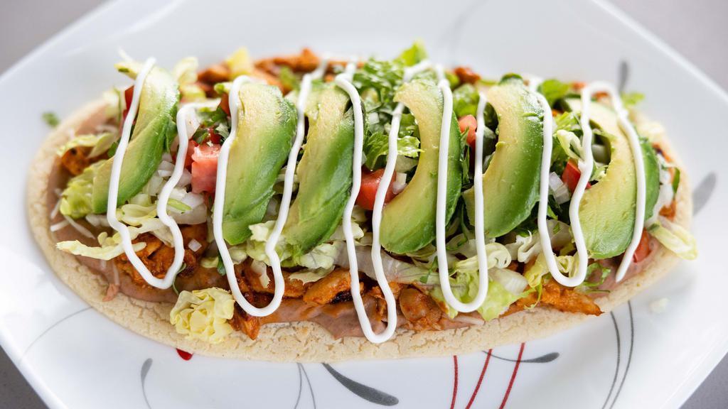 Huarache · Thick corn tortilla topped with beans, lettuce, tomato, avocado, sour cream, cheese and choice of protein.
