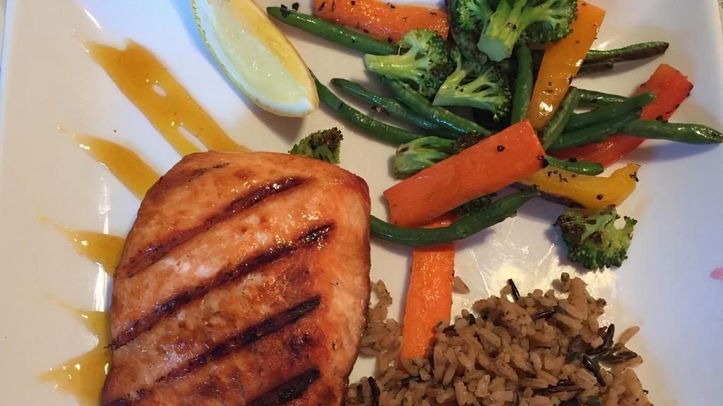 L'Orange Salmon · Fresh salmon fillet grilled to perfection, and finished with an orange honey glaze. Served with seasonal vegetables and wild rice.