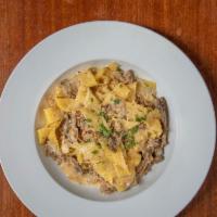 Fettuccine Tartufo · Home made pasta with Italian sausage, mushroom, cream sauce and truﬄe oil.