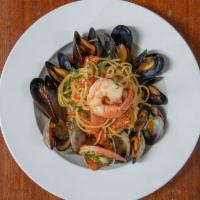 Spaghetti Di Mare · Homemade spaghetti tossed with tiger prawns, clams, mussels, Roma tomatoes, garlic and white...