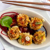 Thai Dumplings · Stuffed ground pork, onion, and water chestnuts wrapped with wonton skin served with black s...