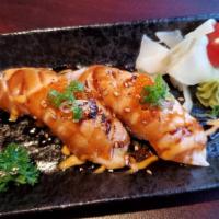Seared Salmon Nigiri · 2 pieces of seared salmon sushi topped with green onion, tobiko, spicy aioli, and soy glaze....