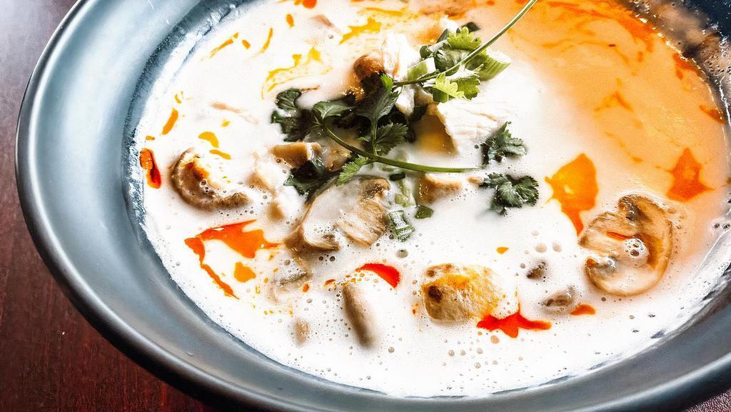 Tom Kah · Coconut milk soup mixed with chili paste and cooked with lemongrass, onions, mushrooms and topped with cilantro and sliced green onions.