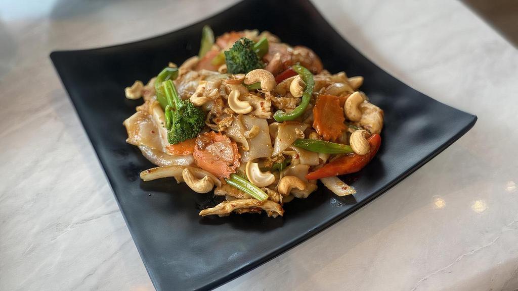 Spicy Cashew Noodle (V) · Wide rice noodles wok fried with egg, bell peppers, broccoli, carrots, roasted cashew nuts, celery, green onions and onions in chili sauce.