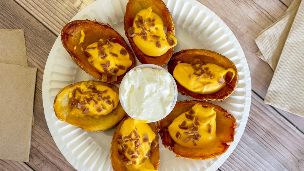 Potato Skins · Six pieces. Cheddar cheese and sour cream with bacon bits.