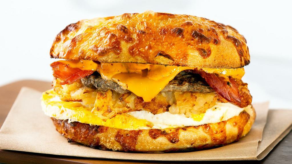 Peace, Love & Breakfast · A fresh-baked 6-cheese artisan roll loaded with two cage free eggs, thick-cut bacon, turkey sausage, and melty American cheese with a smashed hash brown and zesty roasted tomato spread.